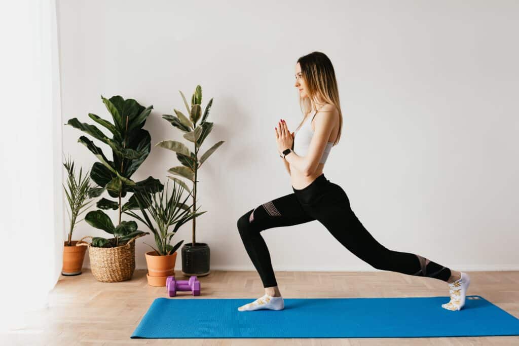 A person wearing black leggings while doing yoga