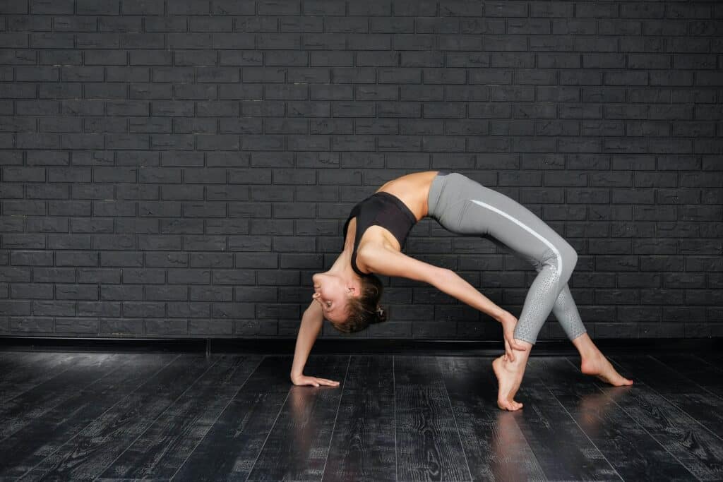 a woman wearing gray leggings stretching her back