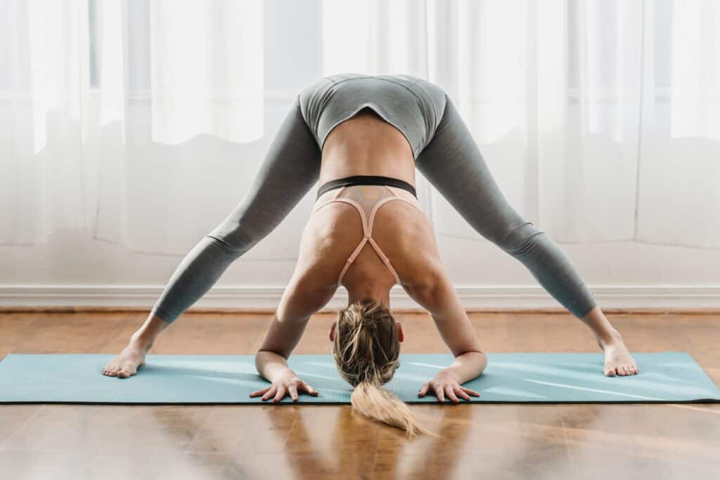 woman doing head stand wearing gray leggings