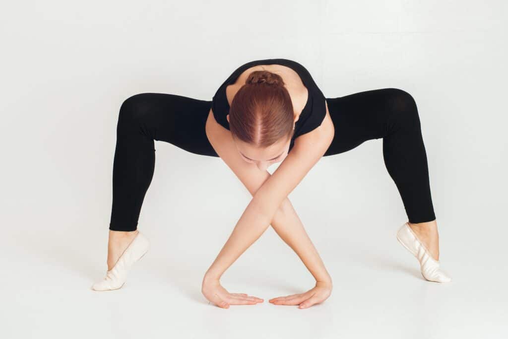 A woman wearing black leggings while stretching