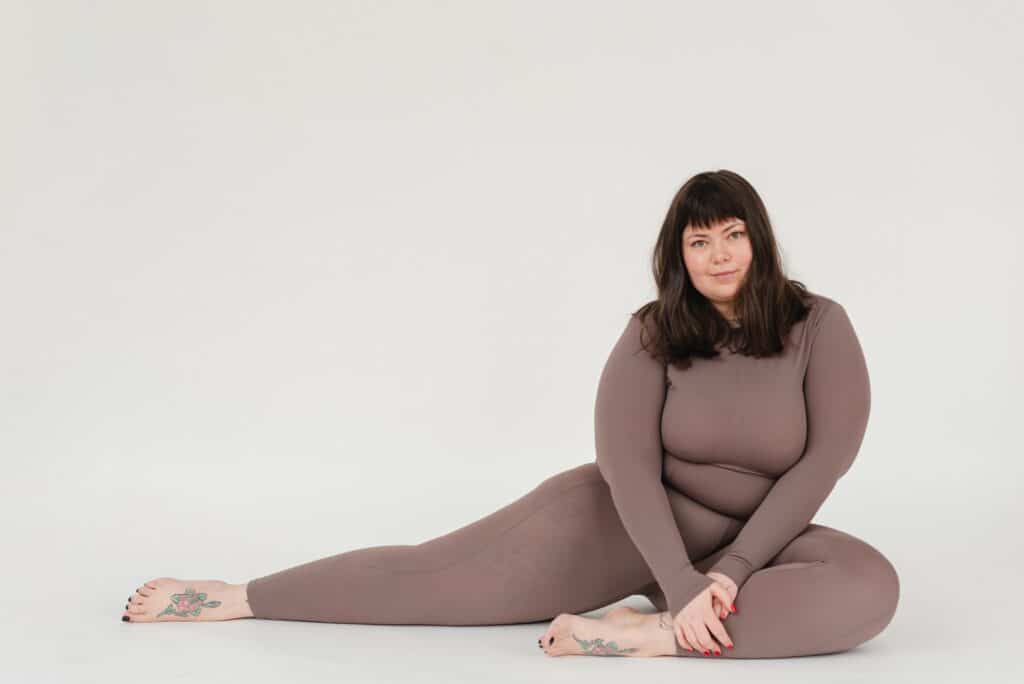 a woman sitting down wearing a brown leggings