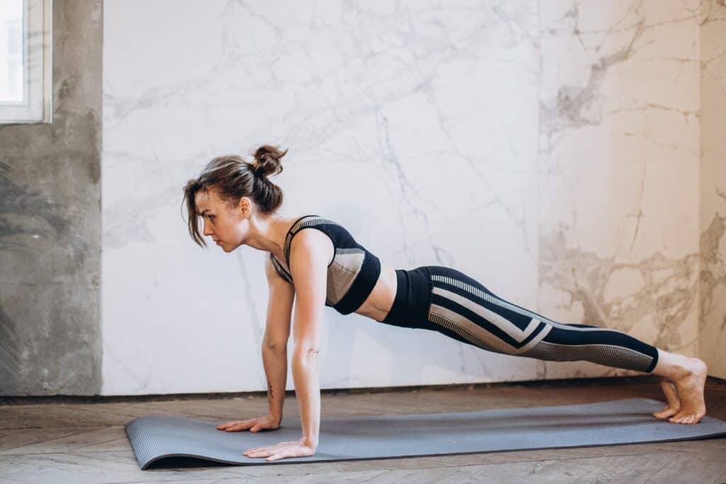 a woman doing a basic plank wearing a see though black leggings