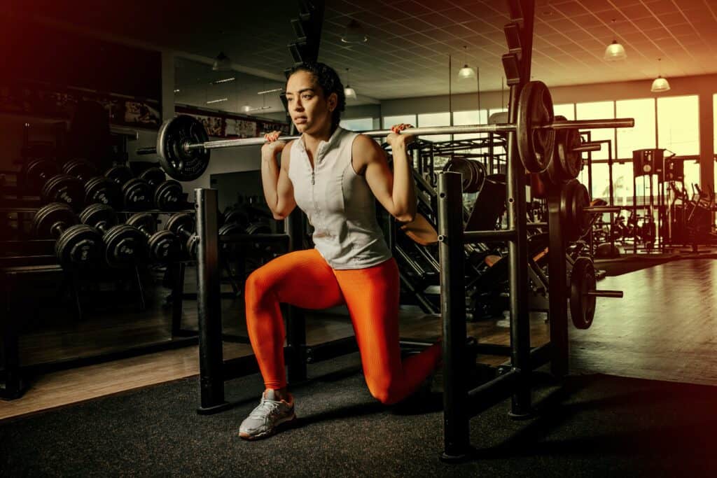 a woman squatting wearing an orange leggings