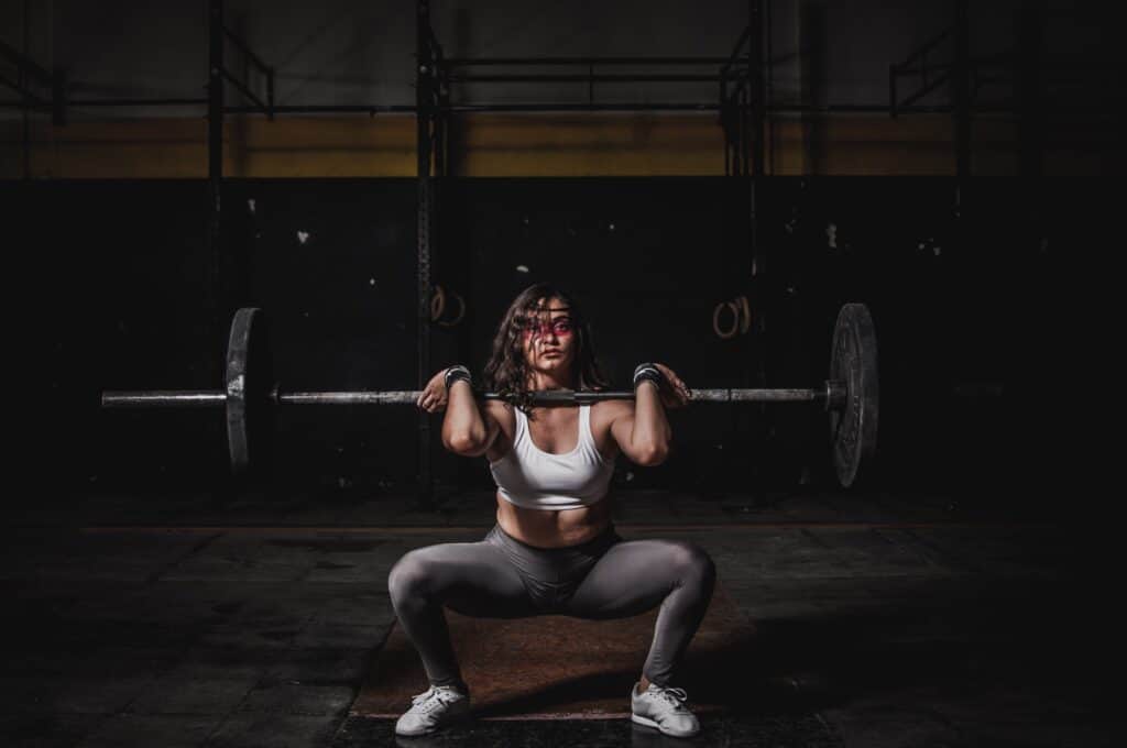 A woman wearing a gray leggings while squatting