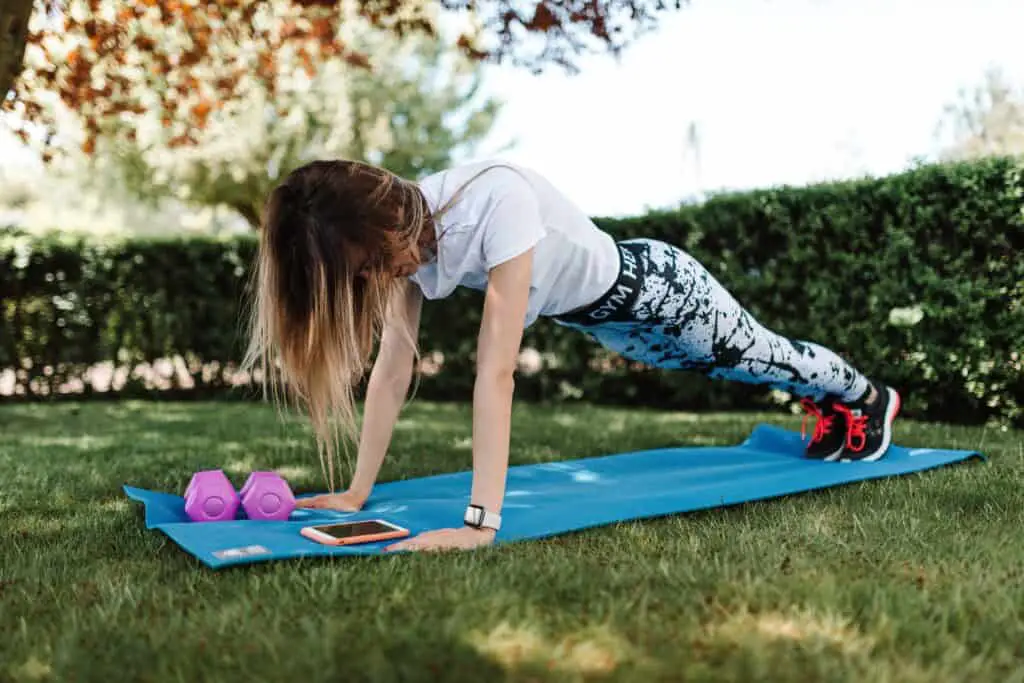 A woman wearing a workout leggings doing a basic plank
