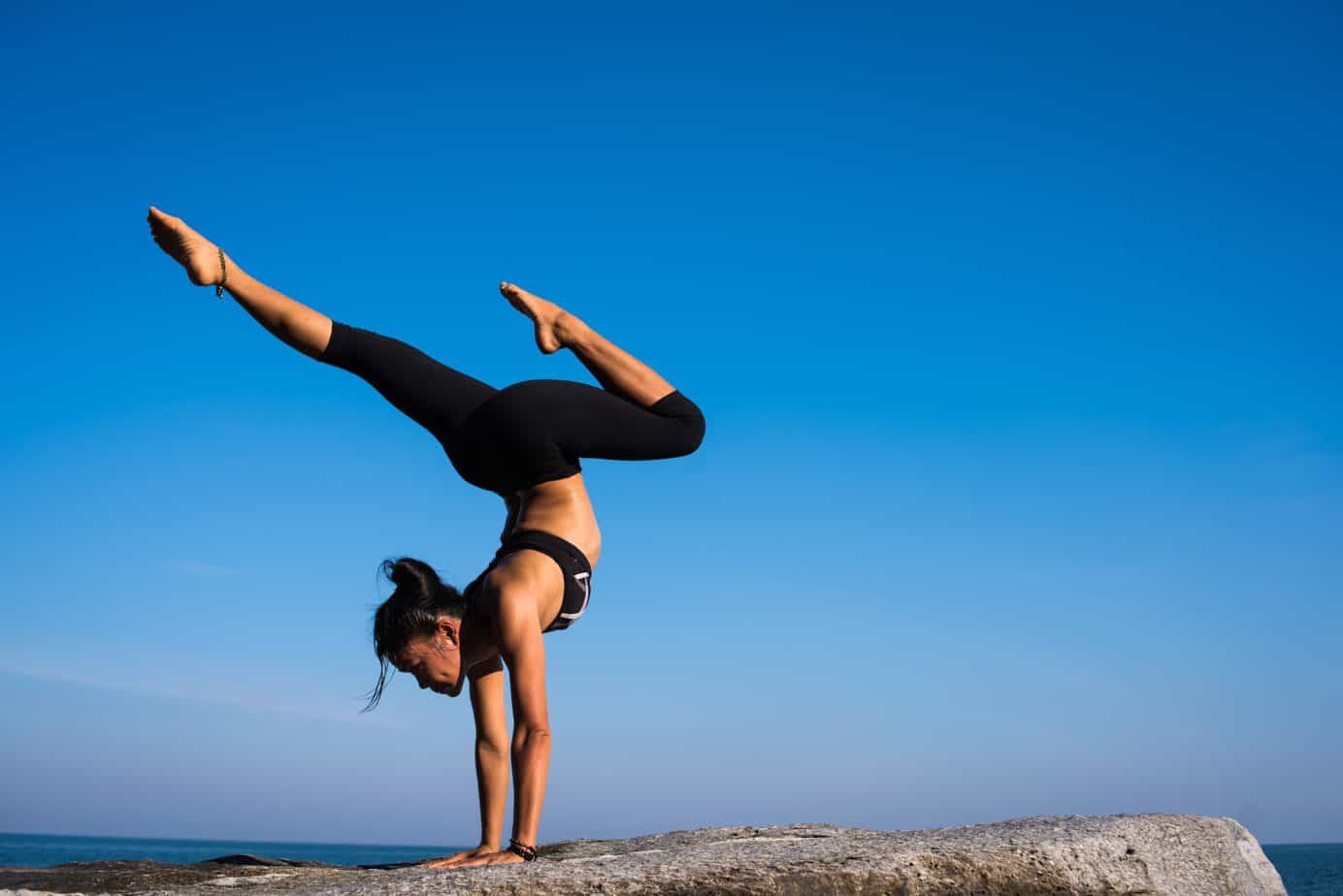 a woman weaaring black leggings while doing yoga pose