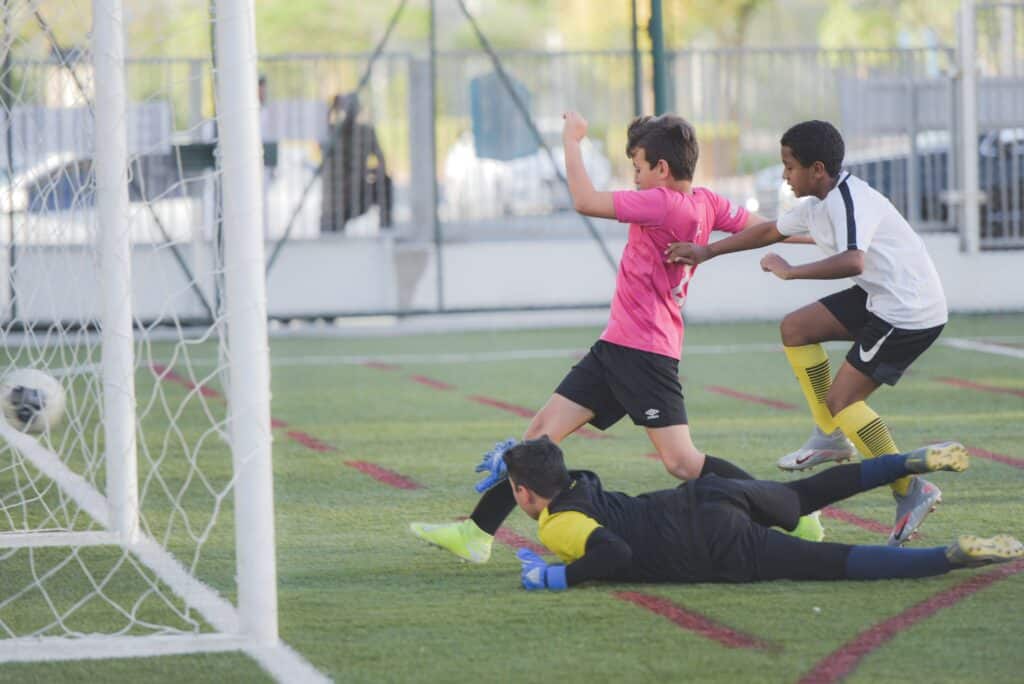 3 boys playing one wearing black shorts over leggings