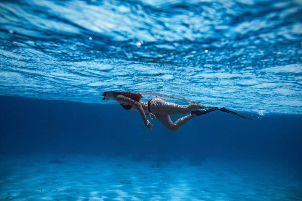 a woman swimming wearing a swimsuit