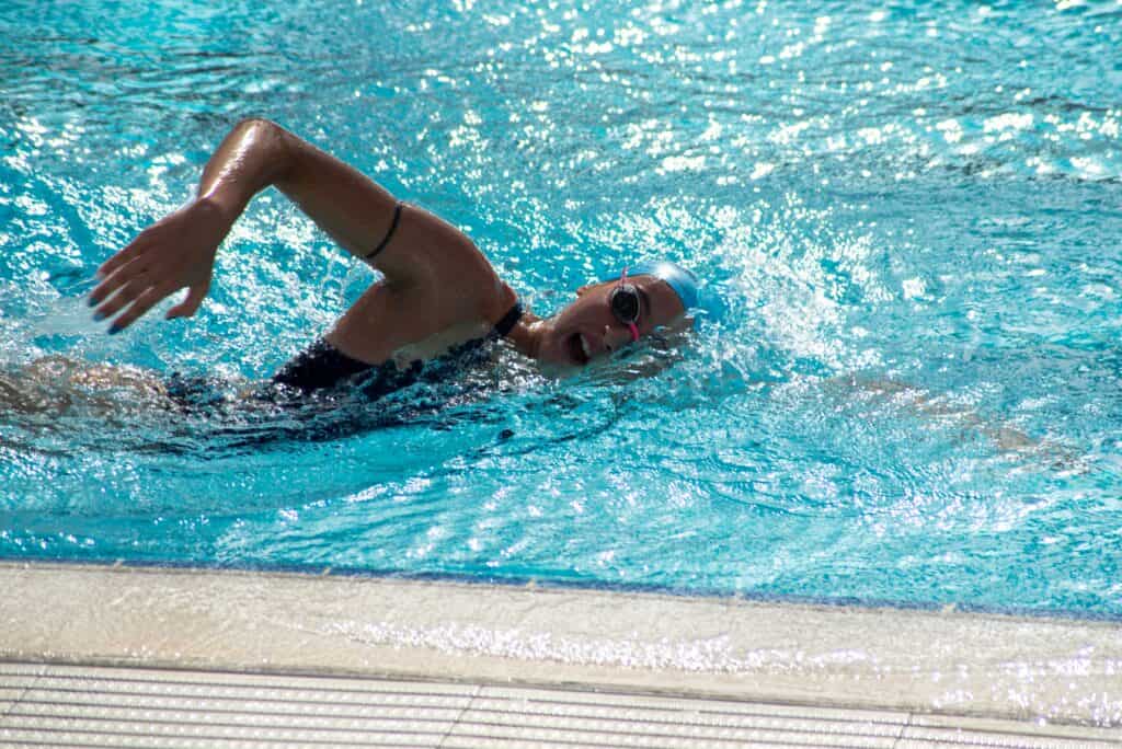 Sidestroke yapan bir yüzücü mayo giyiyor