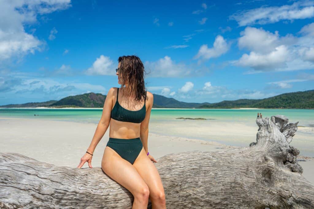 a woman sitting wearing a high waisted bikini