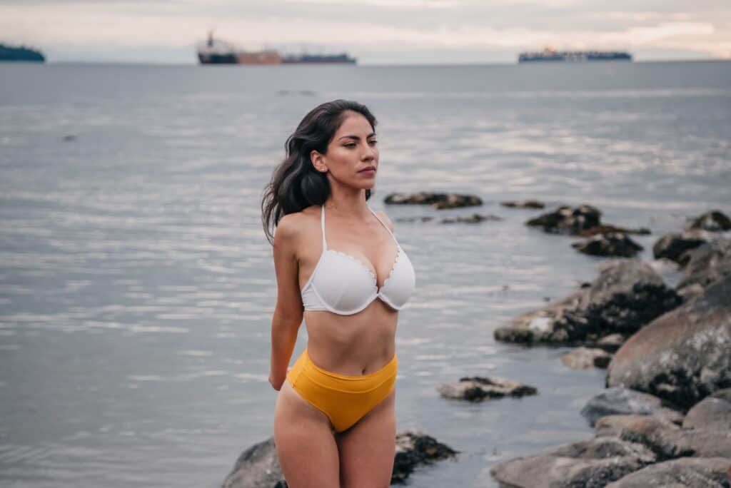 a woman stretching arms wearing a high waisted bikini