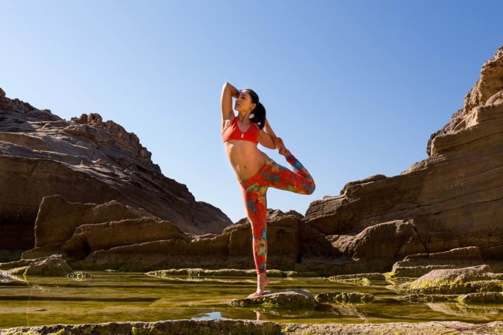 a woman standing in one leg wearing a printed leggings