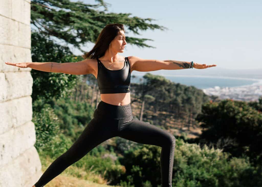 a woman wearing black leggings doing yoga