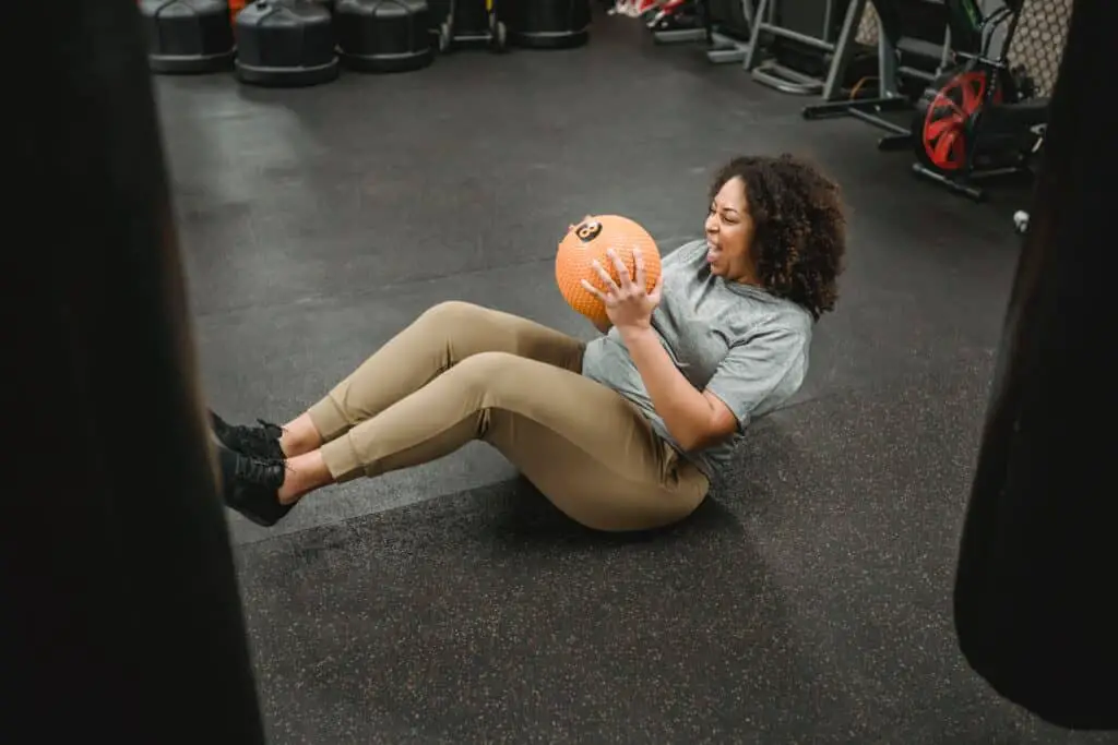 a woman holding a ball wearing leggings