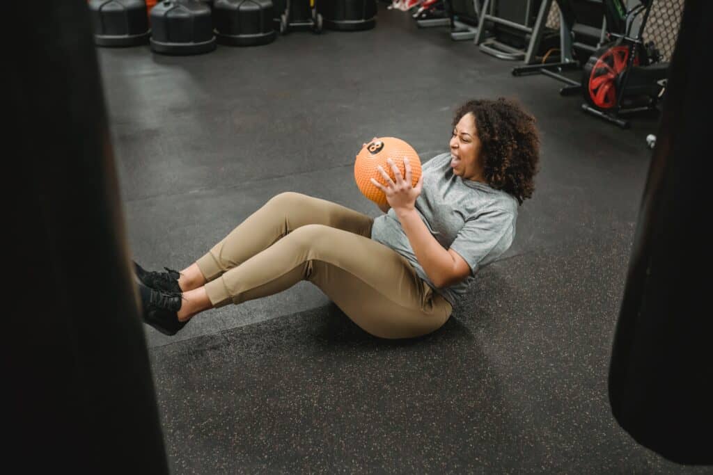 a woman holding a ball wearing leggings