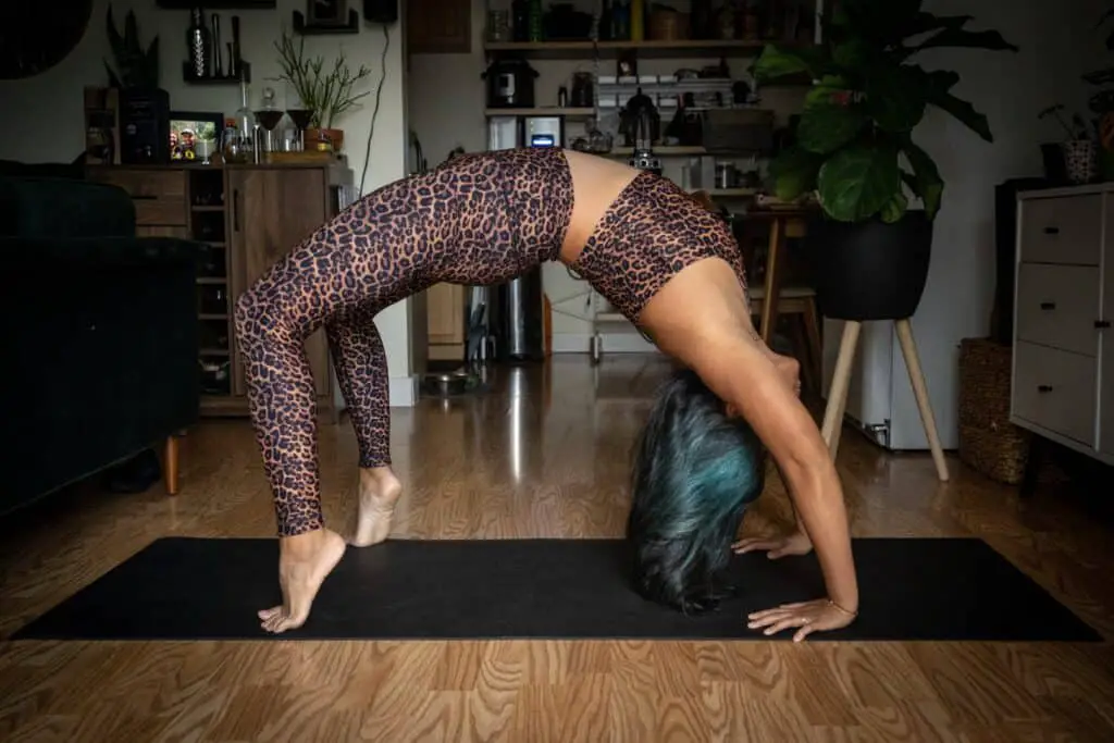 a woman stretching wearing printed leggings and bra