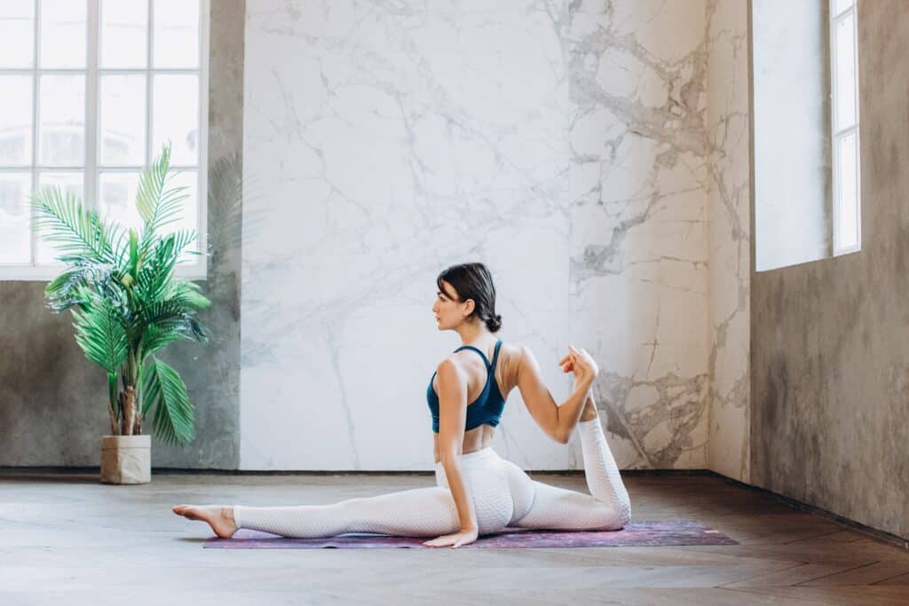 a woman wearing nylon leggings while stretching legs