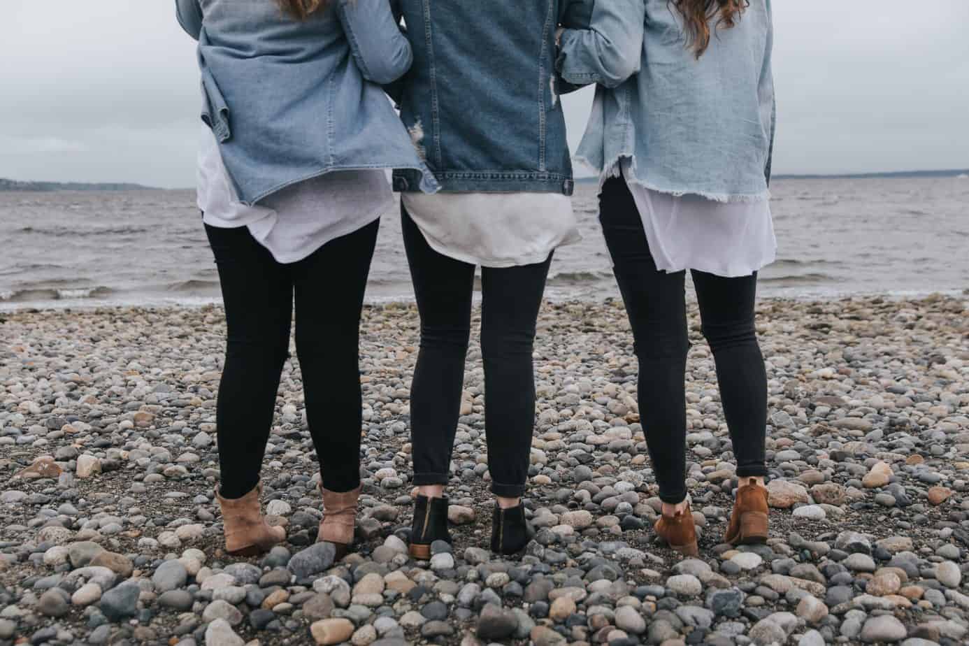 Three women on the beach wearing jeggings