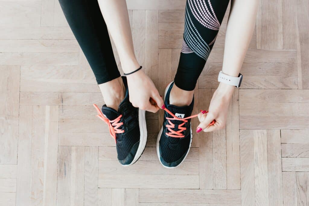 a person tying shoelace wearing printed leggings