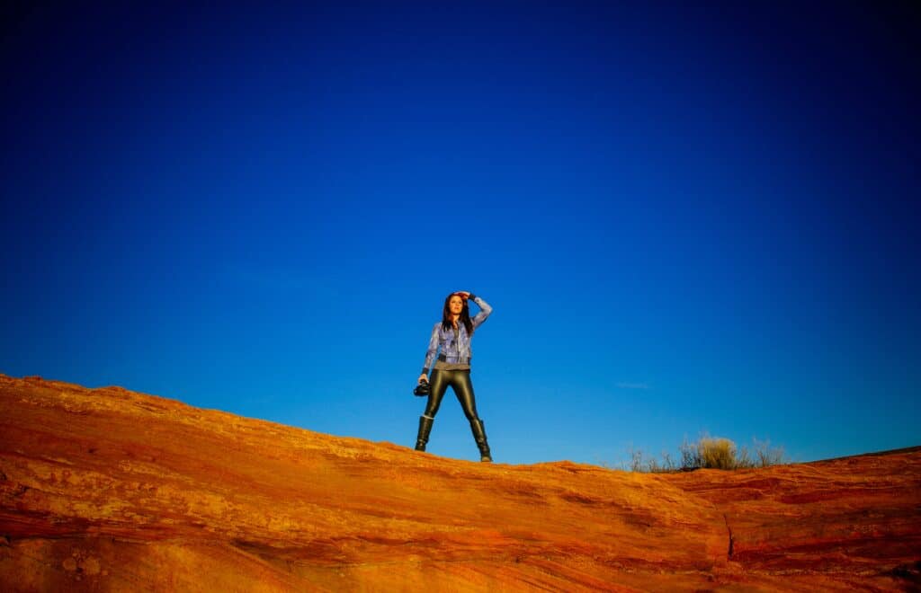 a woman standing on a mountain wearing black leggings