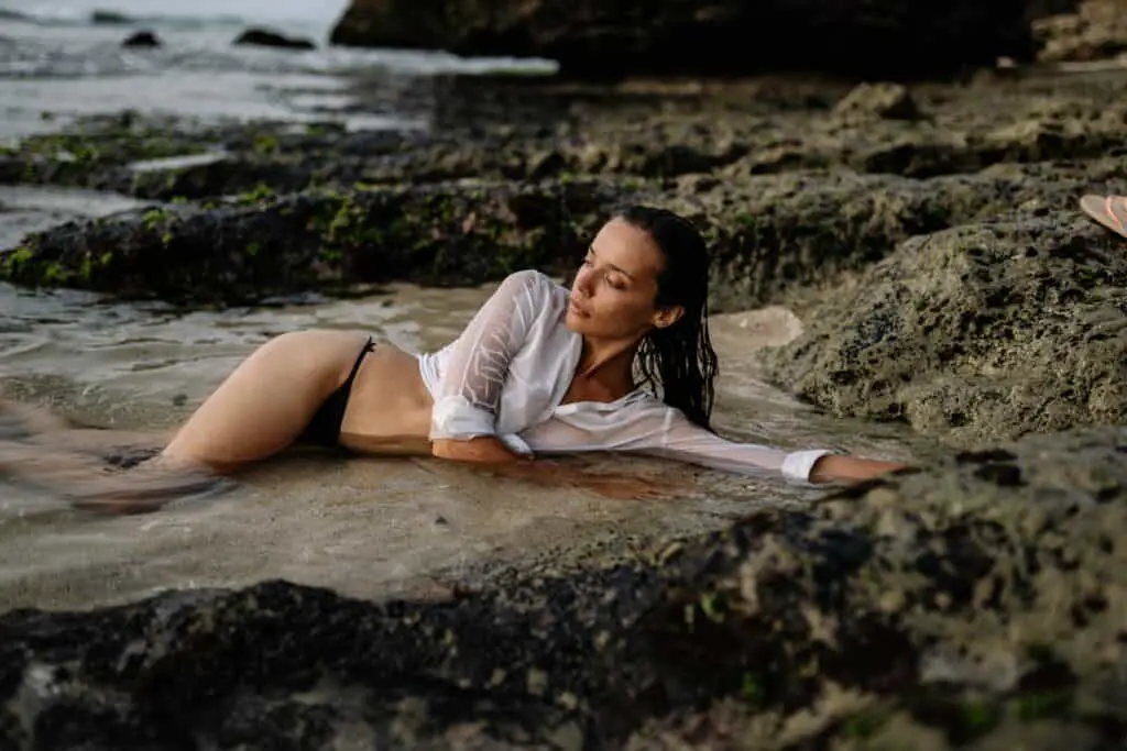 a woman lying down wearing a Brazilian bikini bottom