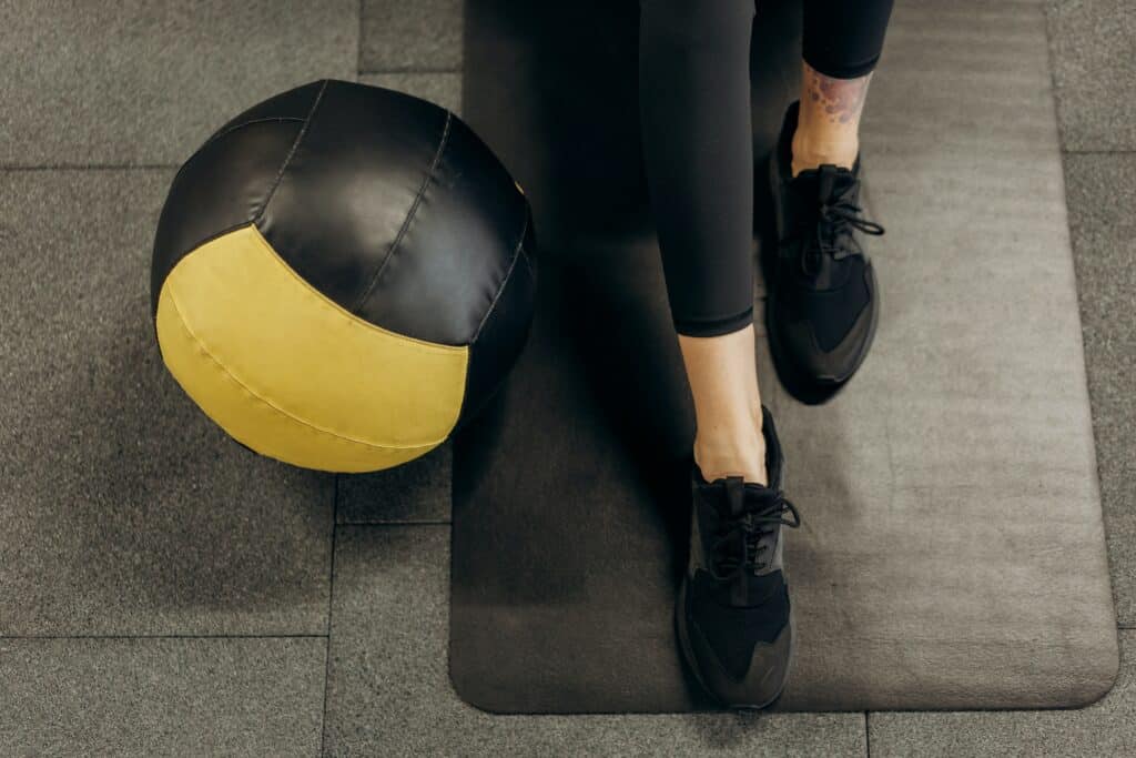 a person wearing black 7/8 leggings beside a ball