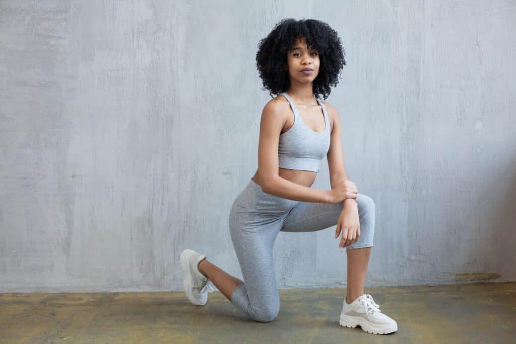 a girl kneeling in one knee wearing gray 7/8 leggings