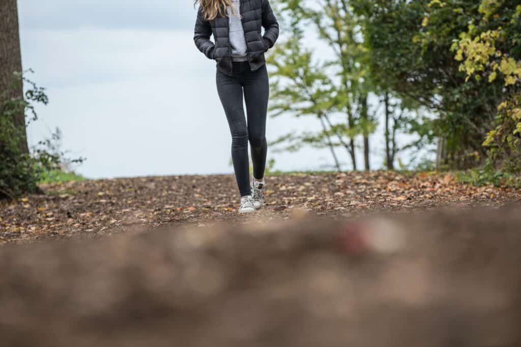 A woman walking on a road wearing leggings