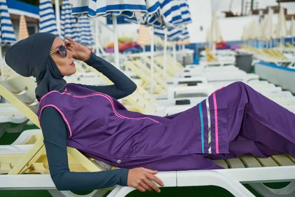 a woman on a bench wearing a burkini