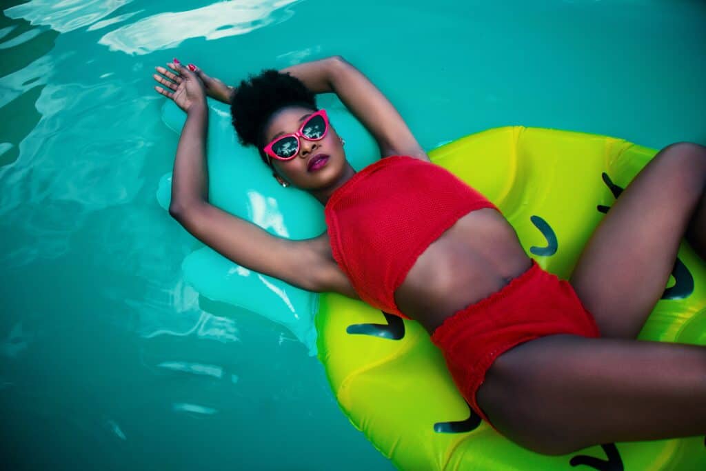 a woman lying on an inflatable toy wearing a red tankini top