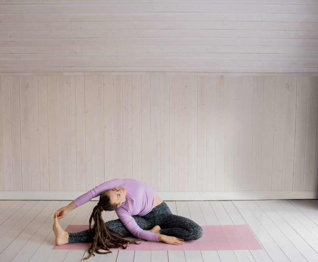 a woman stretching wearing grey leggings