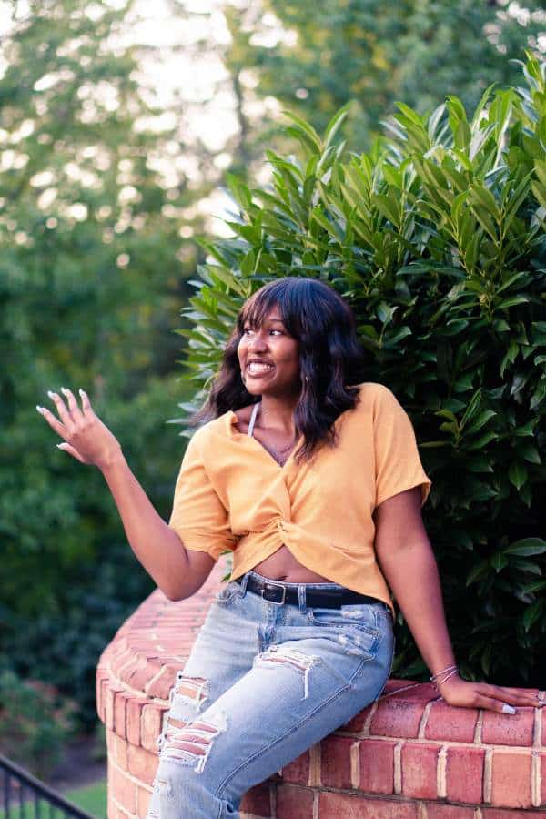 Girl wearing ripped jeans and a yellow blouse