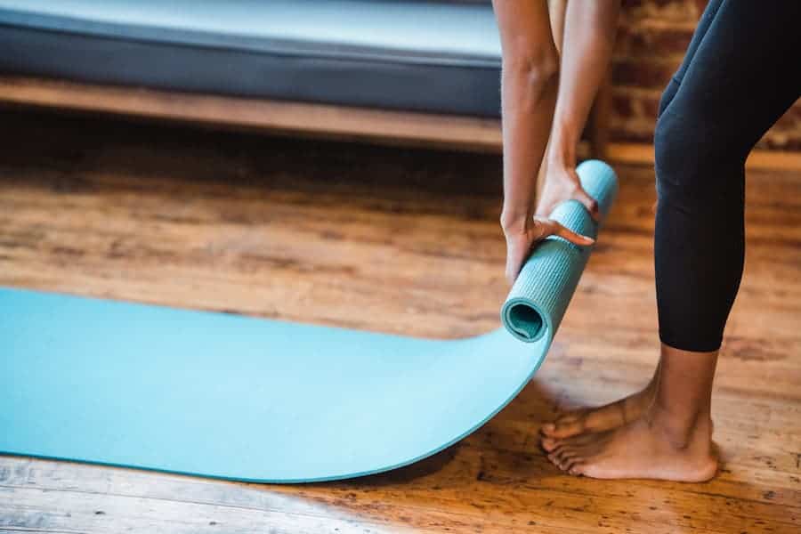 Woman preparing a mat while wearing leggings