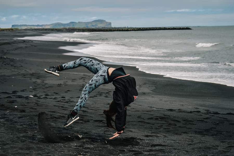 Woman doing backflip while wearing simple addiction leggings