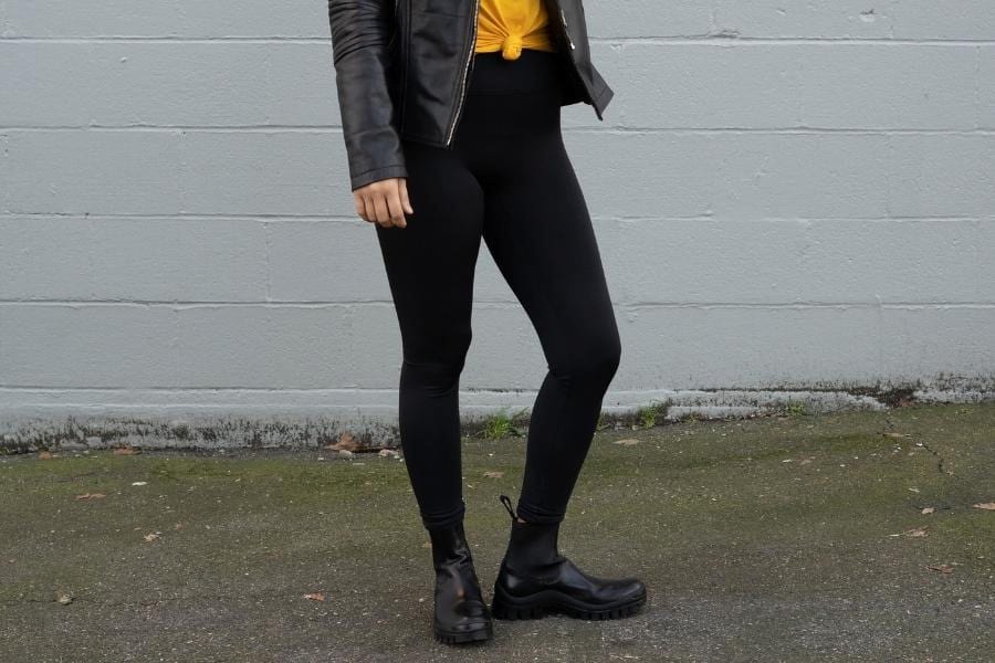 An image of a person wearing a leather jacket, leggings, and boots