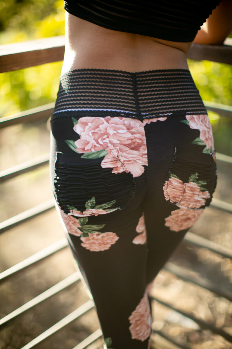 A person wearing a black leggings with a floral design