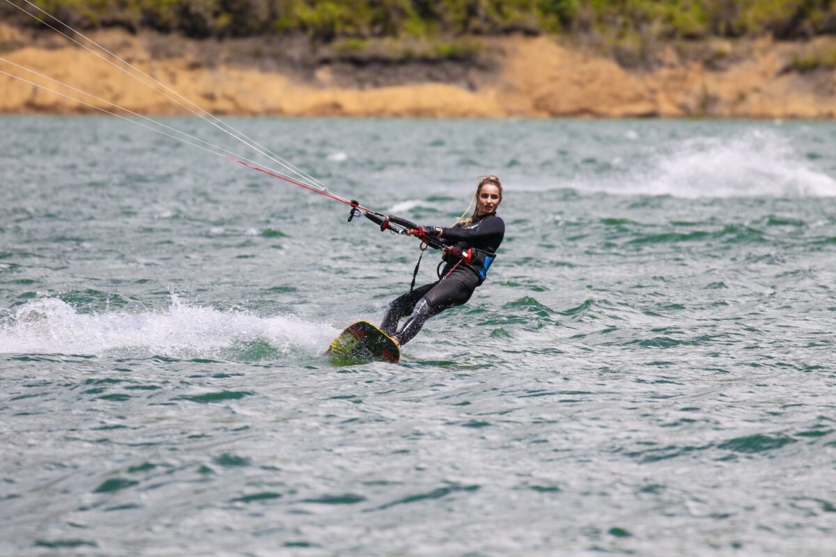 A woman wearing a black rashguard enjoying a nice wakeboarding activity