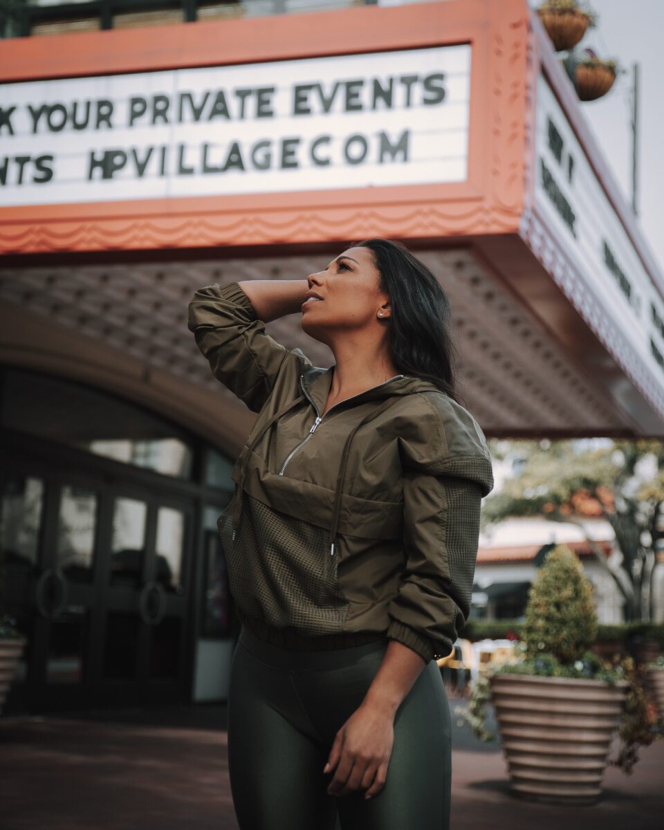 A woman wearing a green jacket and wet look leggings